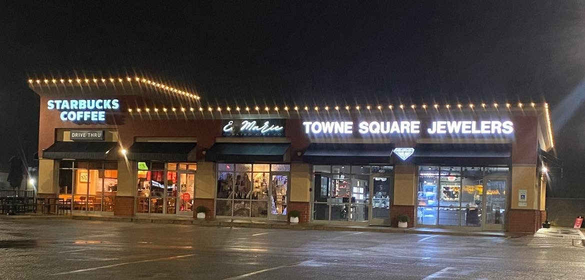 Retail plaza storefront outlined in warm white C9 lighting